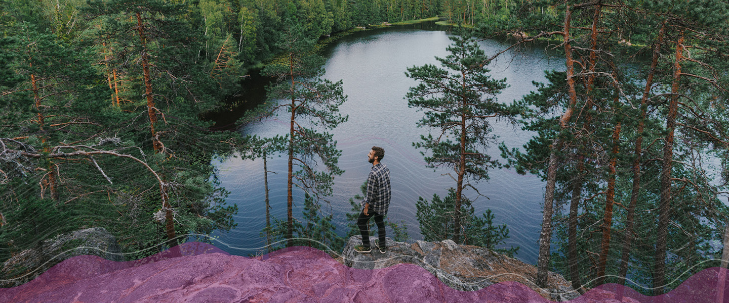 Tule kehittämään tulevaisuuden sähköverkkoa kanssamme! Kuvassa mies kalliolla veden äärellä katselee kaukaisuuteen.