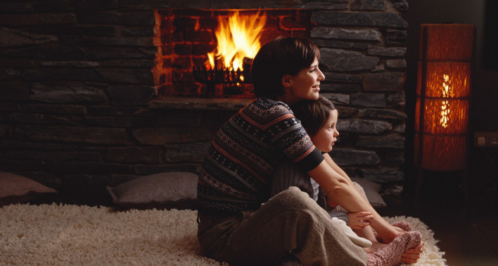 Nainen ja lapsi takkatulen äärellä